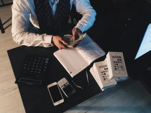 Forkland Debt Refinancing person counting money with smartphones in front on desk 210990 300x225